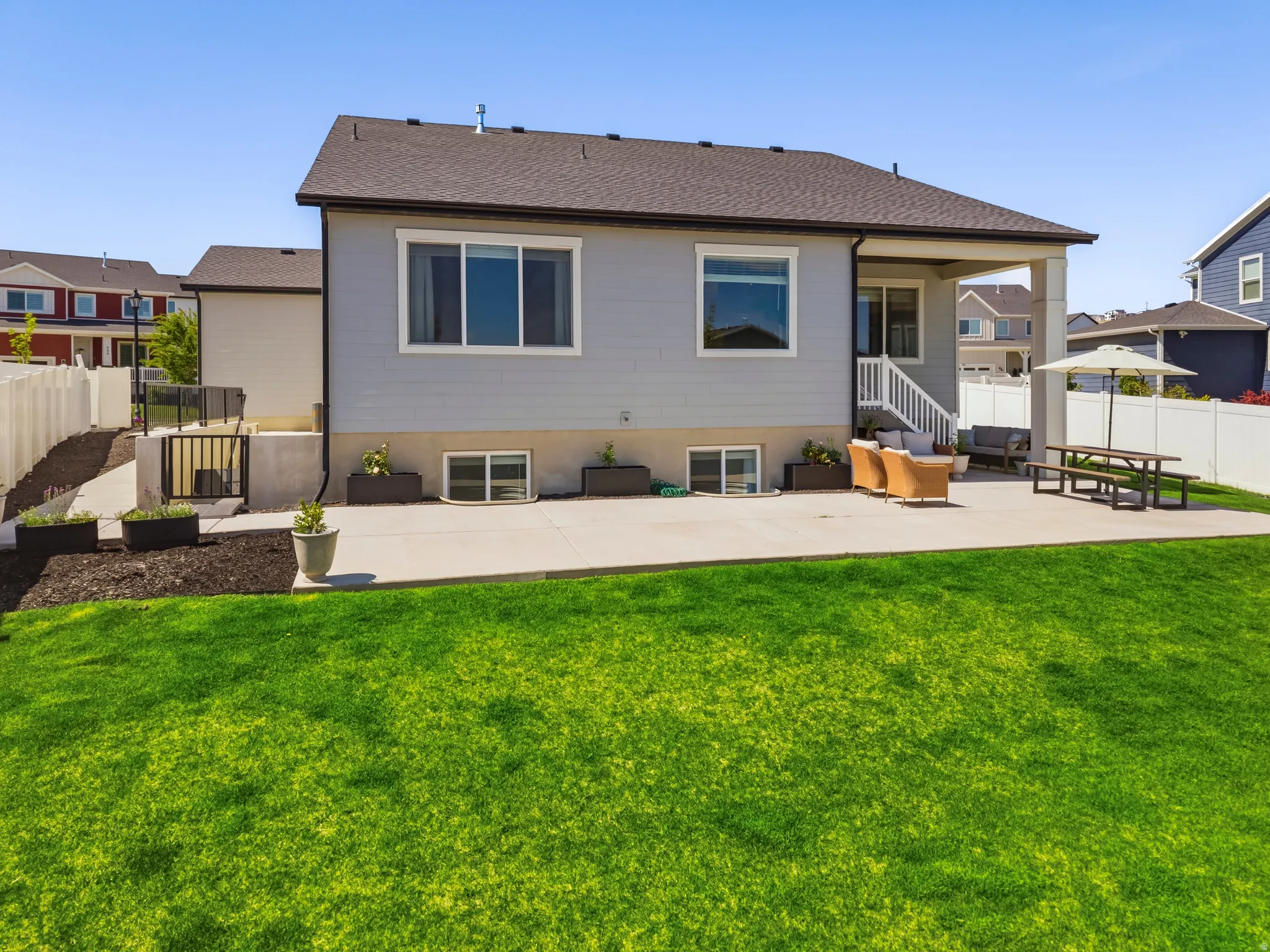 Expansive backyard featuring a lush lawn, a concrete patio, and a covered patio area