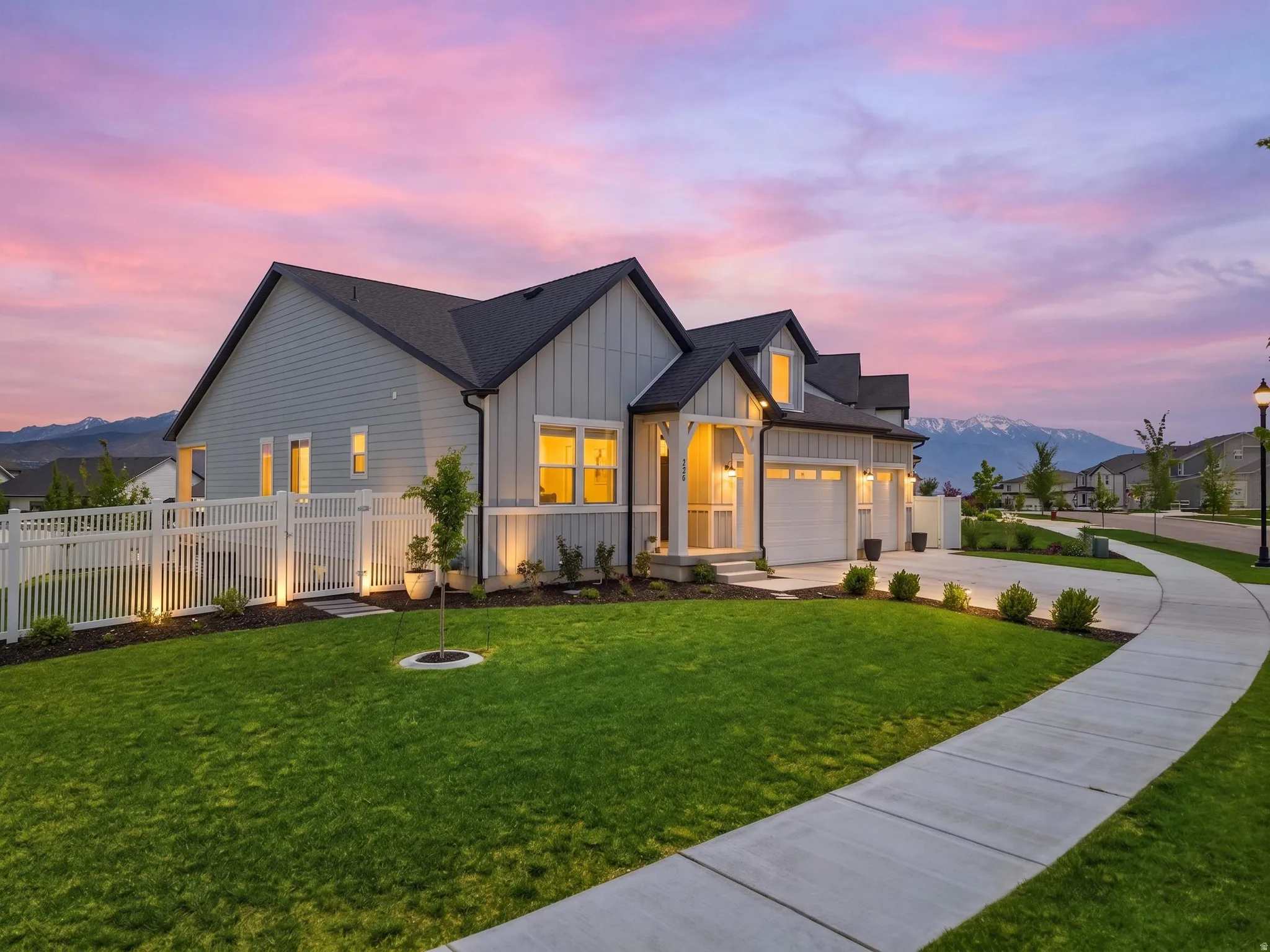 Contemporary residence featuring light gray siding with white trim accents and a dark roof