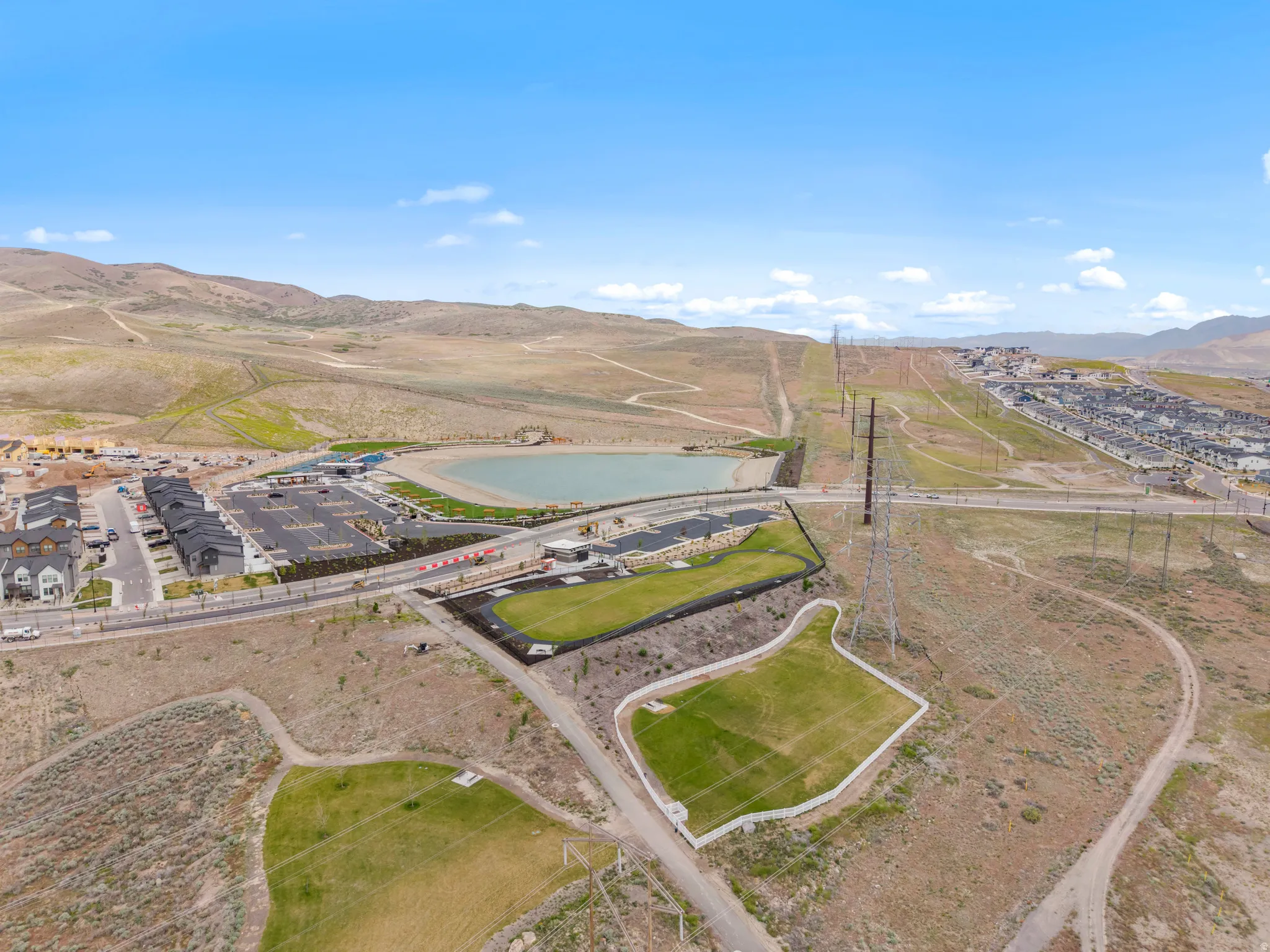 Aerial panorama showcasing a community with a central lake feature and surrounding residences
