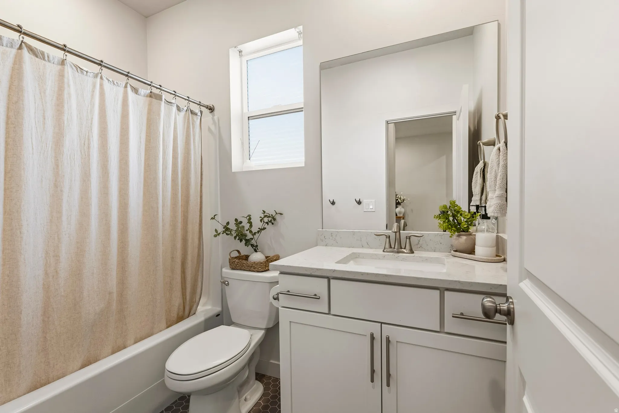 Bathroom featuring a white bathtub, a toilet, and a vanity with a rectangular sink