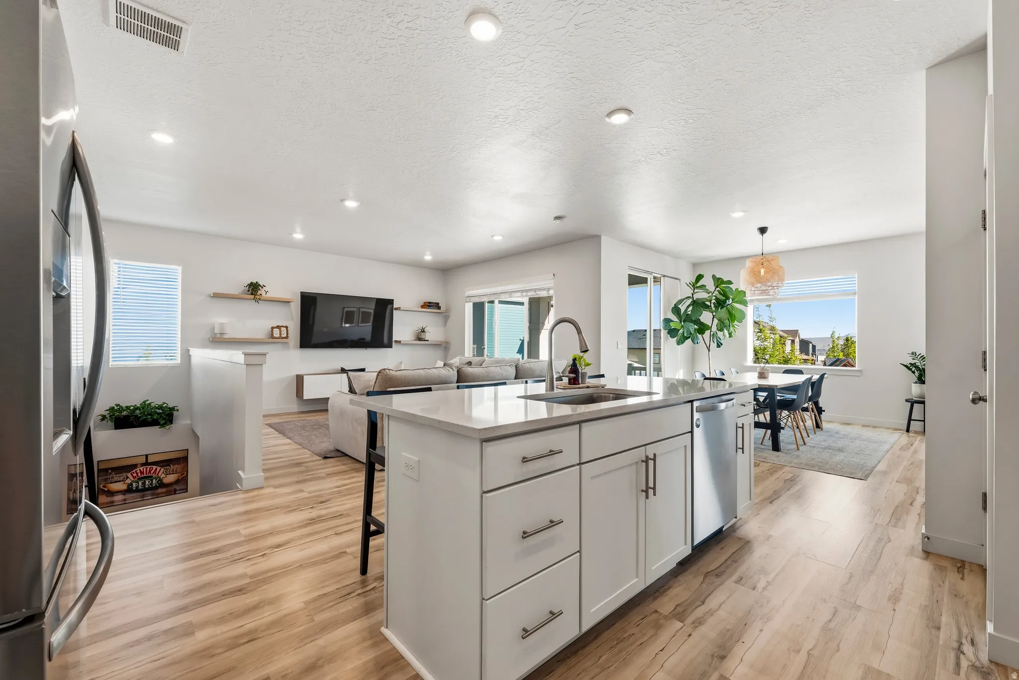 Open-concept interior featuring wood-finish flooring, white walls, and recessed lighting