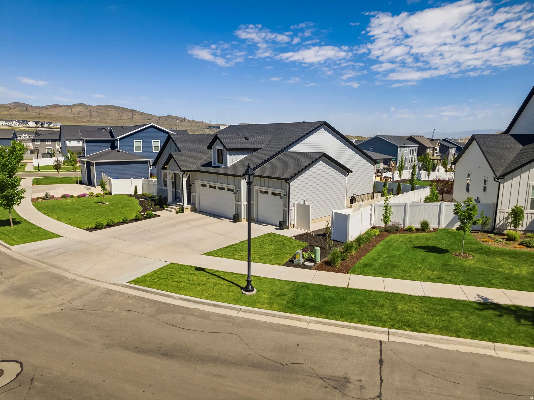 Modern residence featuring light gray siding with black trim accents and a dark roof