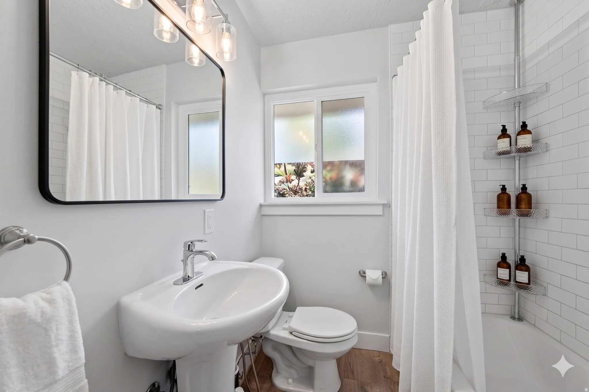 Bathroom featuring a pedestal sink, chrome fixtures, and a rectangular mirror with an overhead light bar