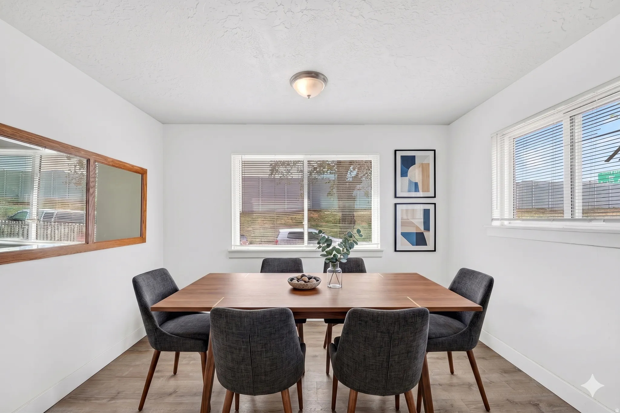 Bright dining area featuring wood-finish flooring, white walls, and a ceiling-mounted light fixture