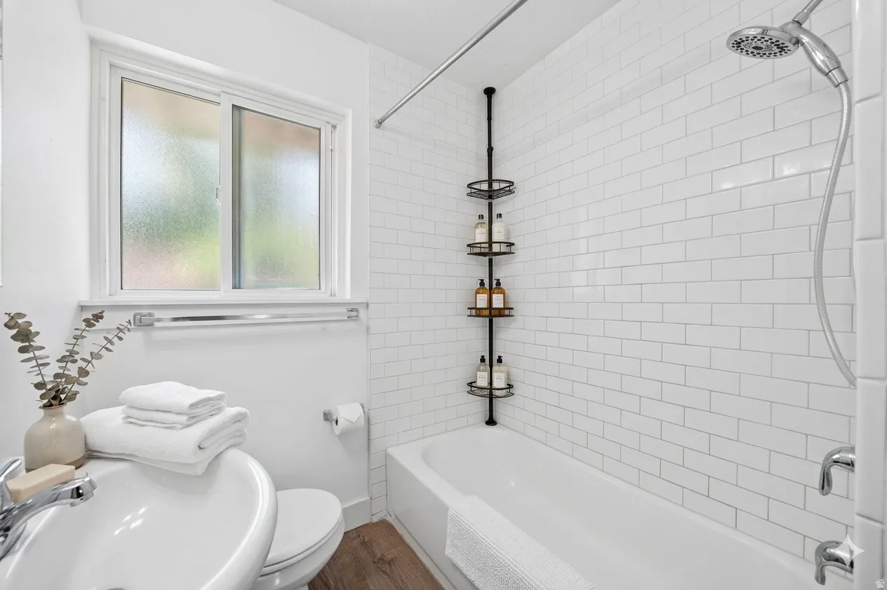 Bathroom featuring a full tub with subway tile surround, chrome fixtures, and a shower head with hose attachment