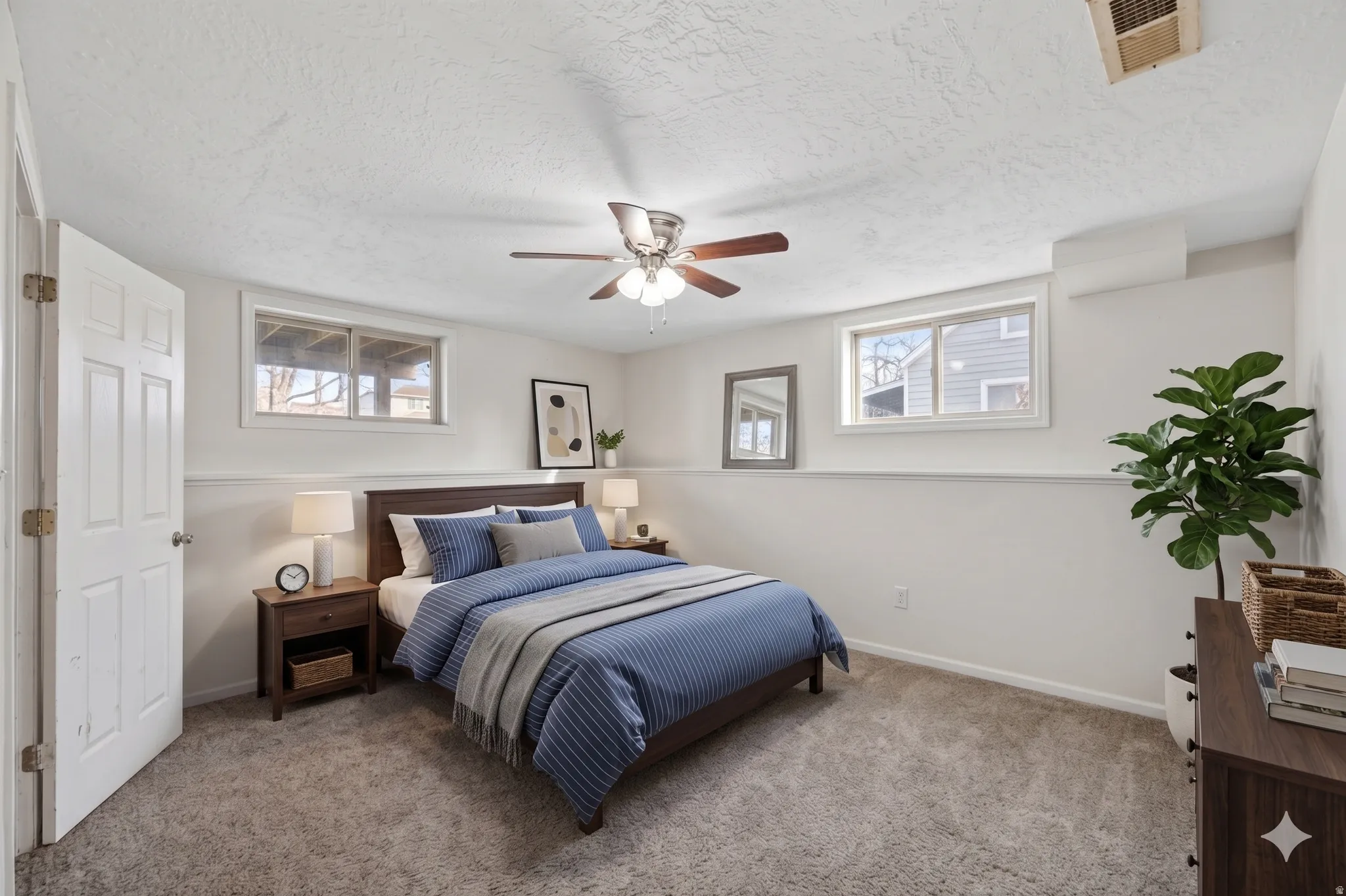 Carpeted room with white walls, a white paneled door, and two horizontal windows