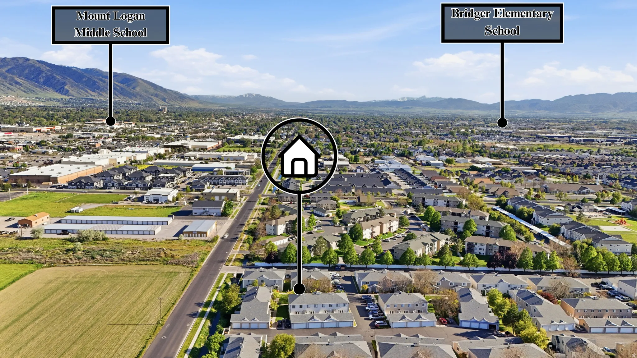 Aerial perspective showcasing a residential community surrounded by mountainous terrain and a distant city skyline
