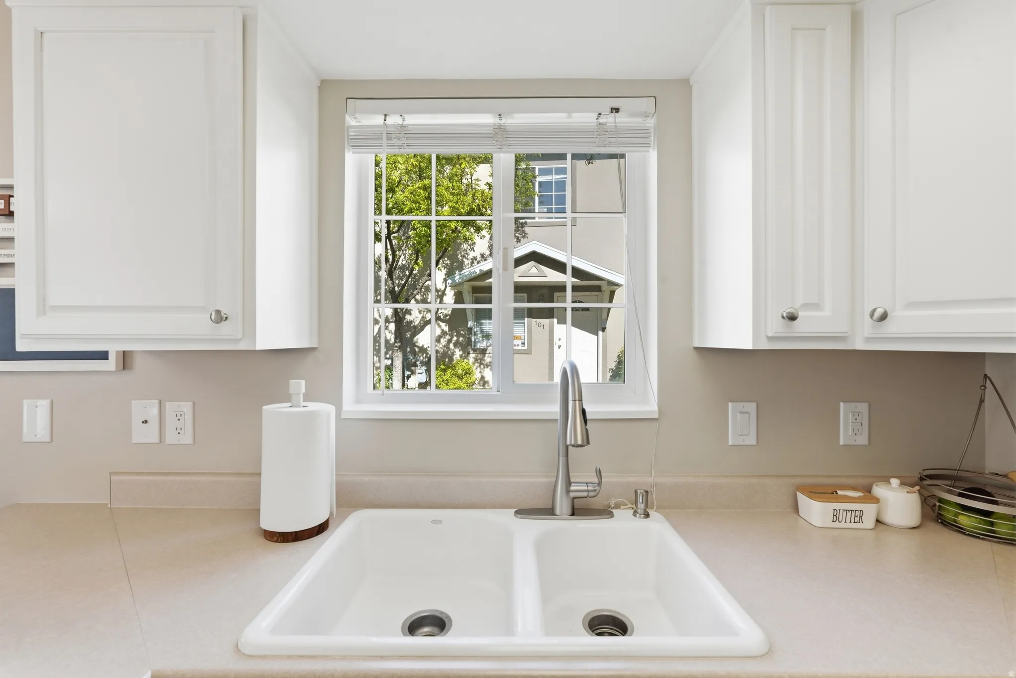 Double basin sink with a chrome faucet, surrounded by solid surface countertops