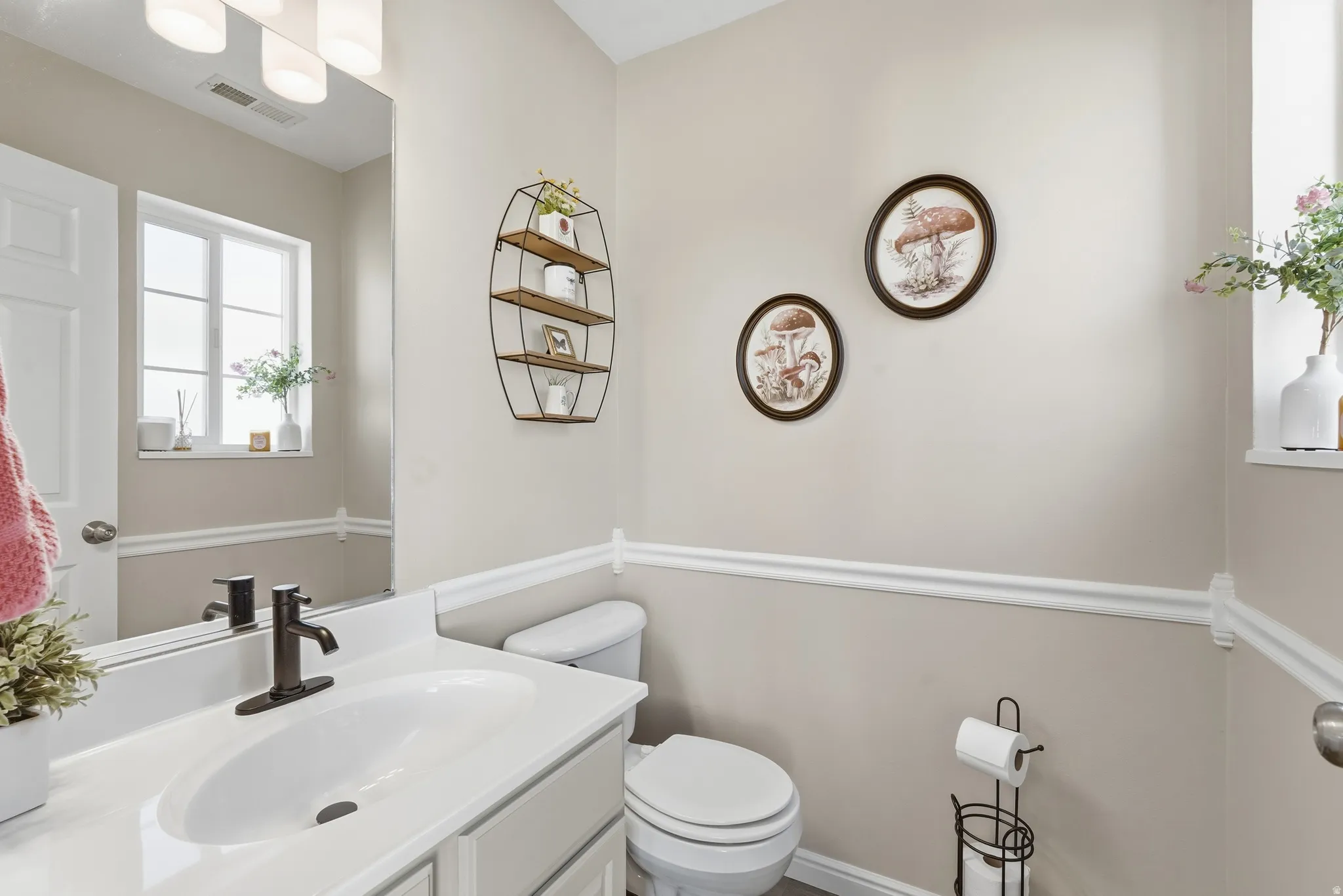 Bathroom featuring a single vanity with an integrated sink, dark bronze-finish faucet, and a large wall-mounted mirror