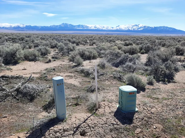 Expansive desert landscape featuring sagebrush and distant snow-capped mountains