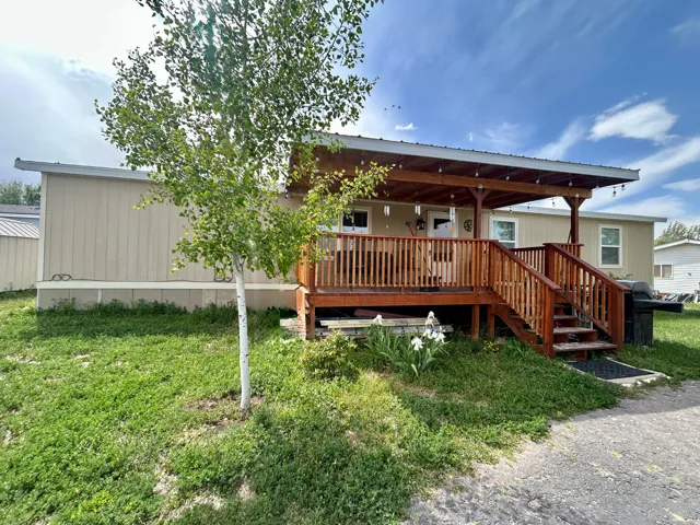 Expansive wooden deck with an overhead cover, integrated steps, and wooden railings