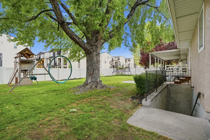 Spacious backyard with mature tree providing natural shade