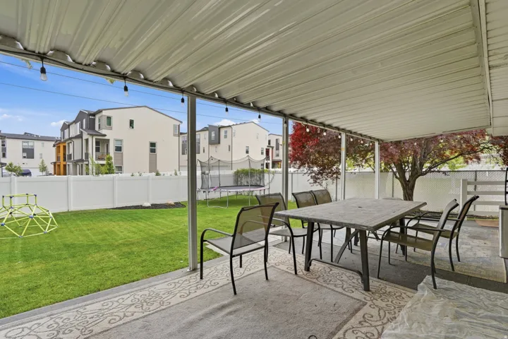 Covered patio featuring string lights, a concrete slab, and an outdoor area rug