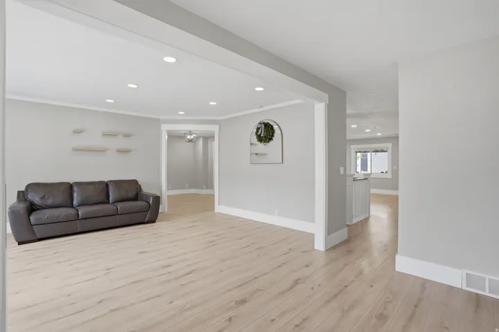 Spacious room featuring light wood-finish flooring, recessed lighting, and crisp white baseboards