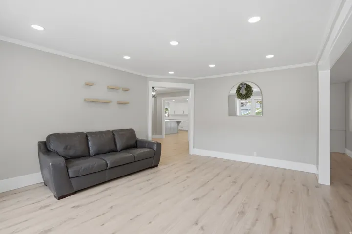 Bright living space featuring light wood-finish flooring, recessed lighting, and crown molding