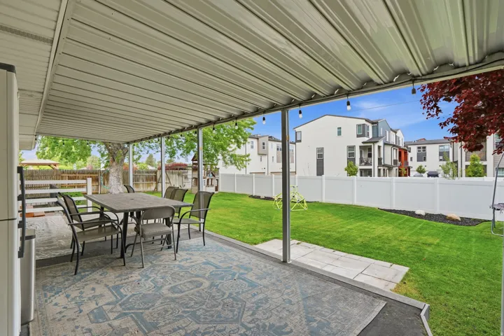 Covered patio with string lighting, offering an expansive outdoor living area