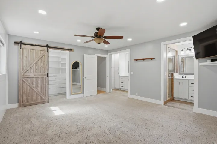Spacious room featuring light gray walls, recessed lighting, and a ceiling fan