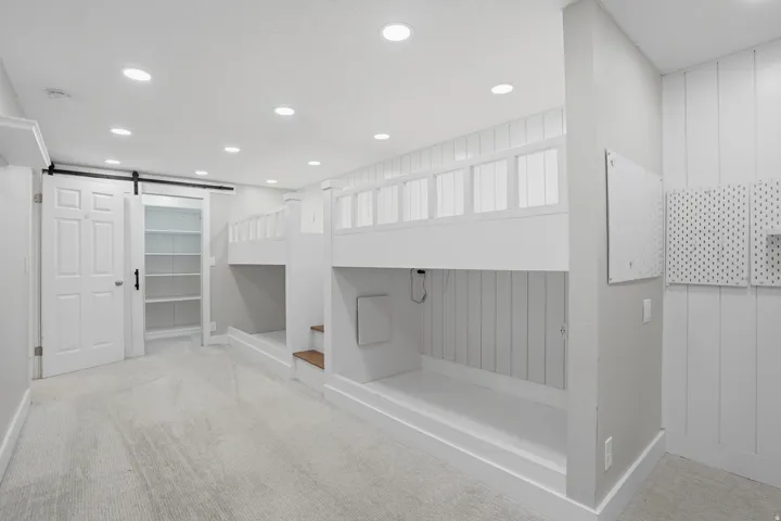 Built-in bunk beds with slatted railings and integrated wood-finish steps