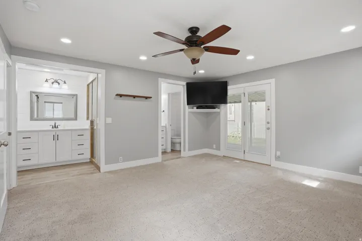 Spacious room featuring neutral carpeting, a ceiling fan with integrated lighting, and recessed ceiling lights