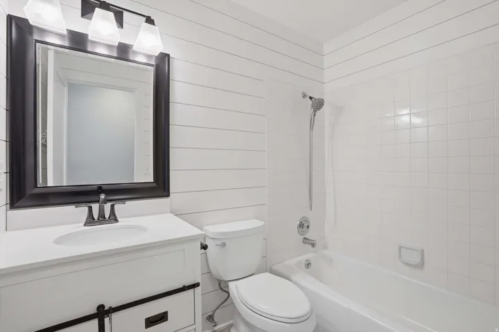 Bathroom featuring shiplap wall paneling and a white vanity with a rectangular undermount sink