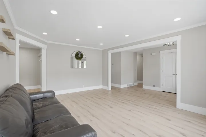 Spacious interior featuring light wood-finish flooring and recessed lighting