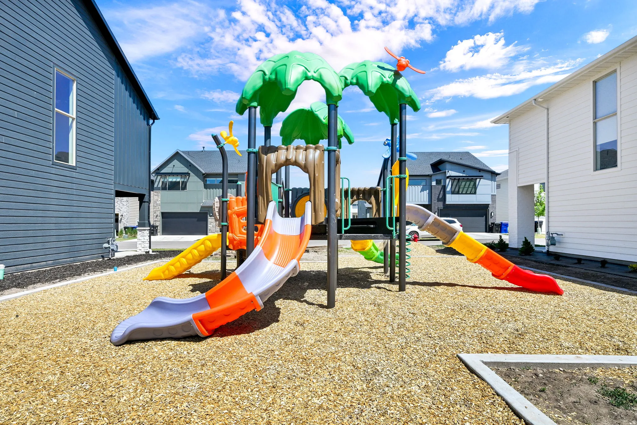 Outdoor play area featuring a multi-level playset with multiple slides and climbing features