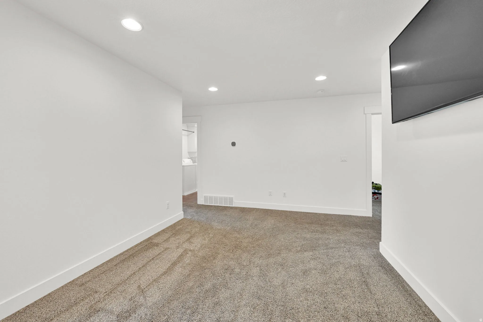Carpeted room featuring recessed lighting, white walls, and white baseboards