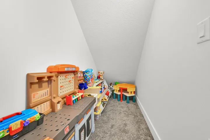 Carpeted nook featuring sloped ceilings and a neutral color palette