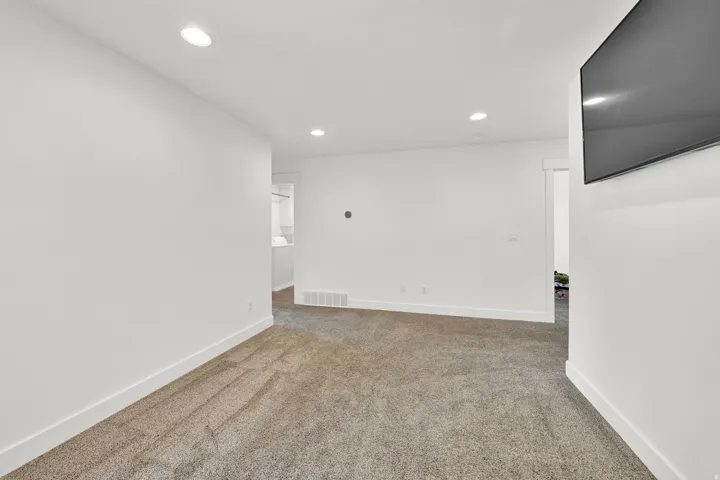 Carpeted room featuring recessed lighting, white walls, and white baseboards
