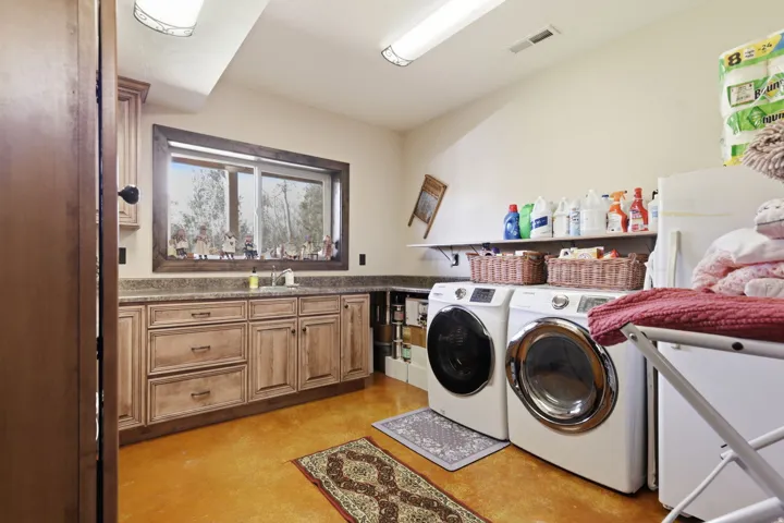 Utility room with built-in cabinetry, an integrated sink, and an expansive countertop