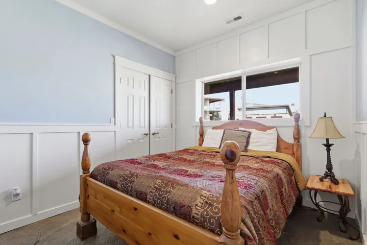 Bright interior space featuring a large window, board and batten wall treatment, two-panel interior doors, and crown molding