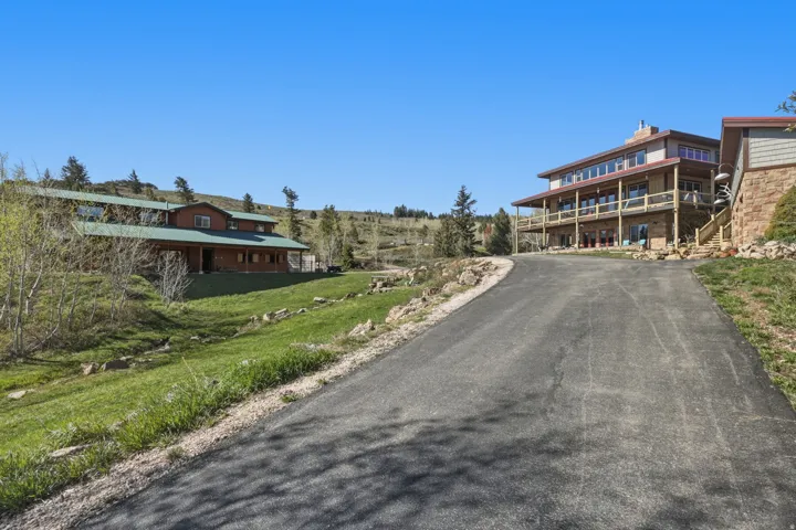 Expansive paved driveway leading to two distinct structures