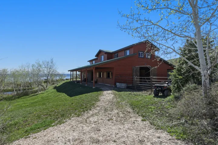 Red-sided barn-style residence featuring a covered porch spanning the length of the building