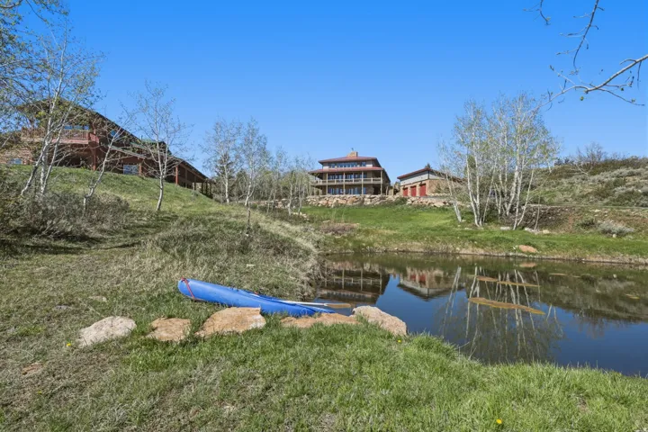 Private pond with natural rock accents and surrounding grassy areas