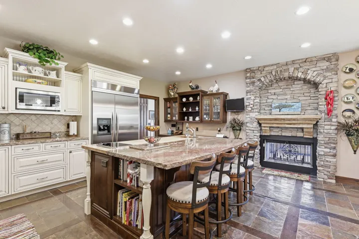 Kitchen featuring a stone-clad fireplace and expansive island with seating