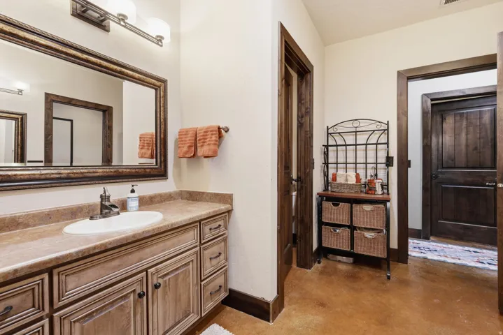 Bathroom vanity featuring a single basin, bronze-finish faucet, and substantial countertop space