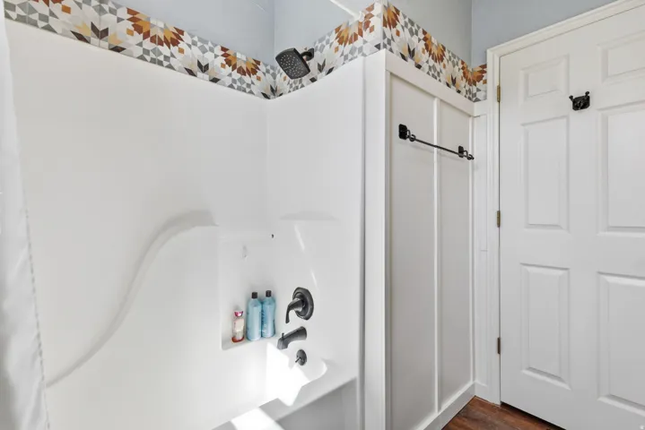 White shower enclosure with black fixtures and a built-in niche