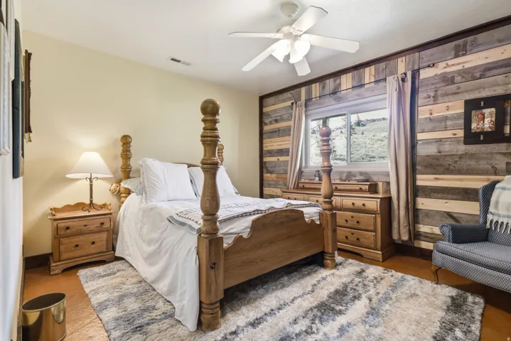 Bedroom featuring a wood-finish accent wall, light-colored walls, and solid surface flooring