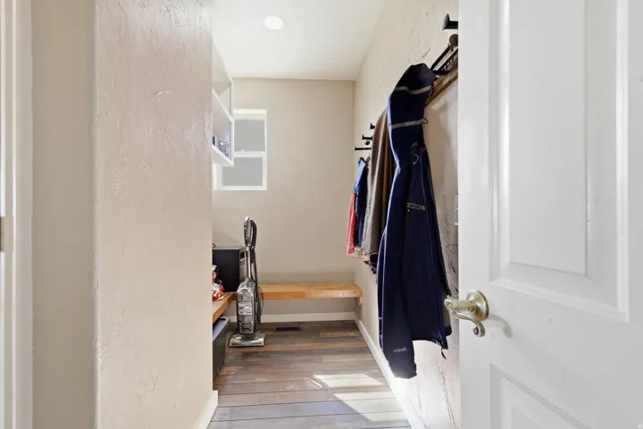 Entryway featuring wood-finish flooring, a built-in wooden bench, a functional window, and recessed lighting