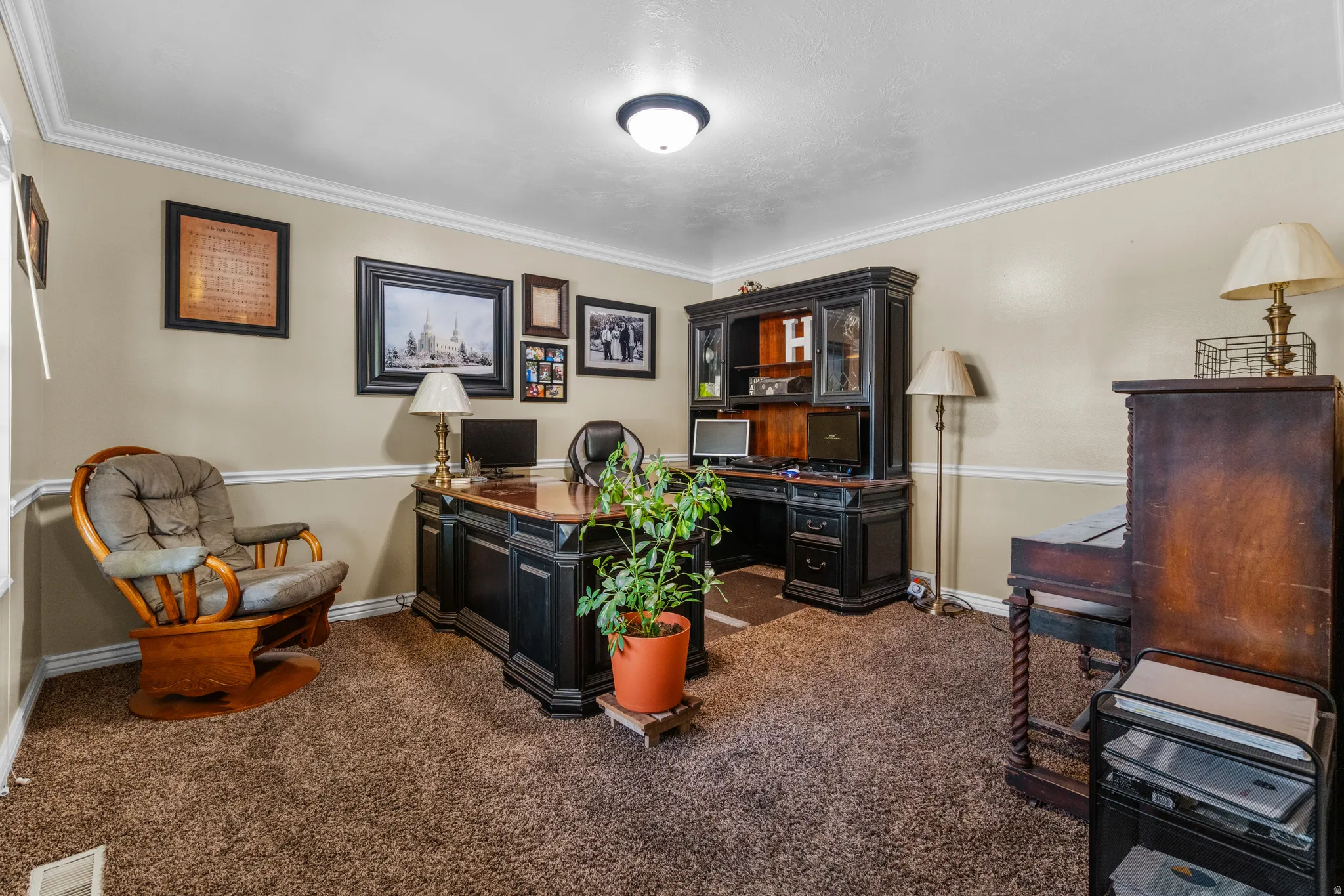 Dedicated office/den space featuring crown molding, neutral wall tones, chair rail detailing, textured carpeting, and a flush-mount ceiling light