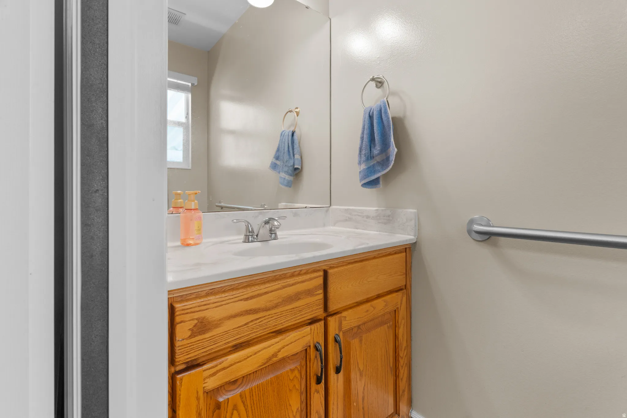 Half bath, featuring wood-finish cabinetry, a built-in sink, and a light-toned countertop