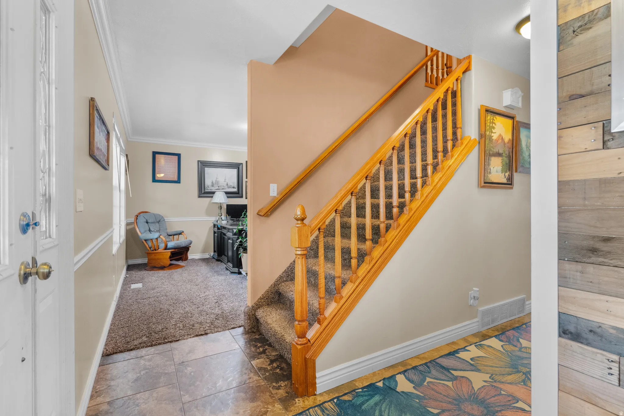 Entry/foyer featuring a wood-finish staircase with carpeted treads and a detailed balustrade