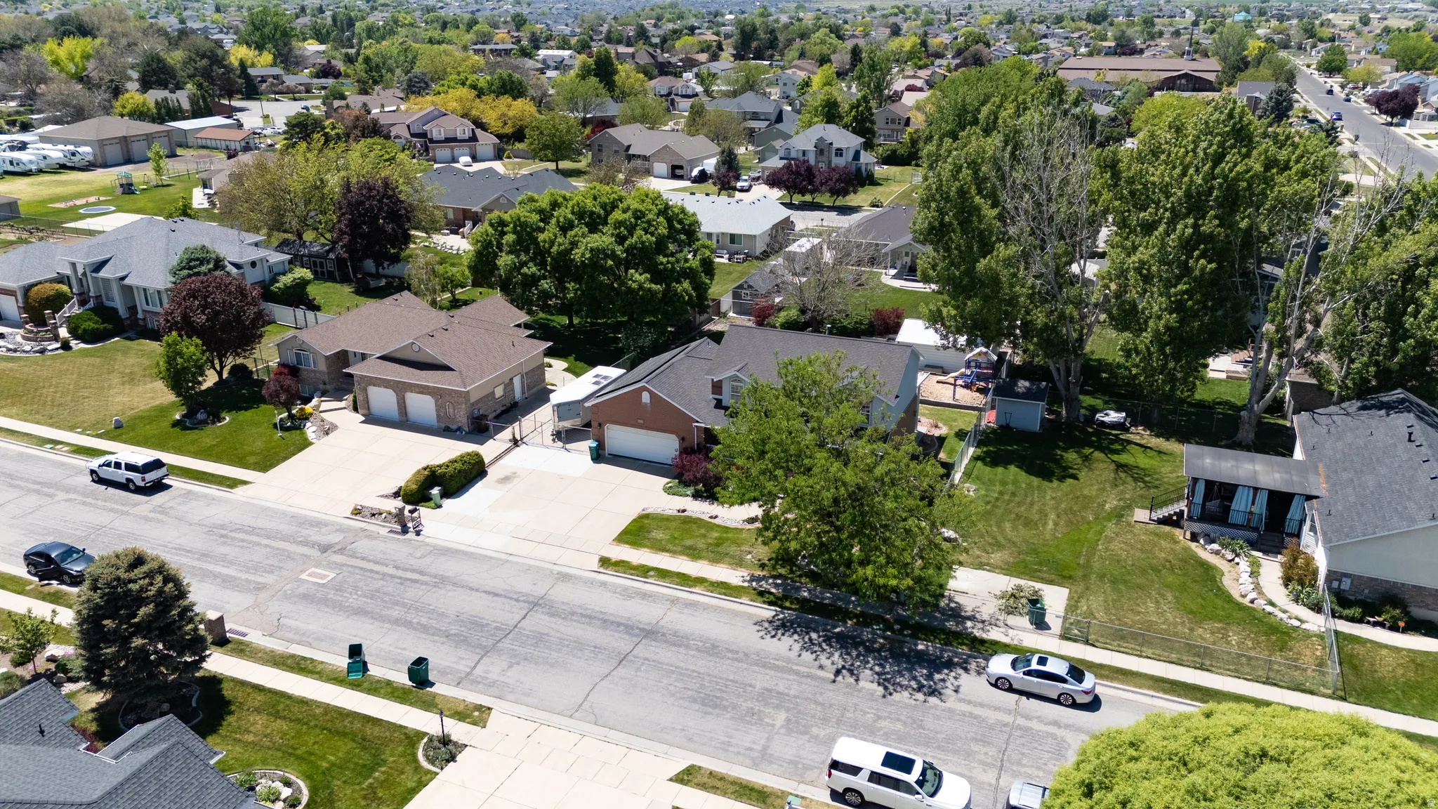 Expansive residential property featuring a large front yard, mature trees, and a concrete driveway