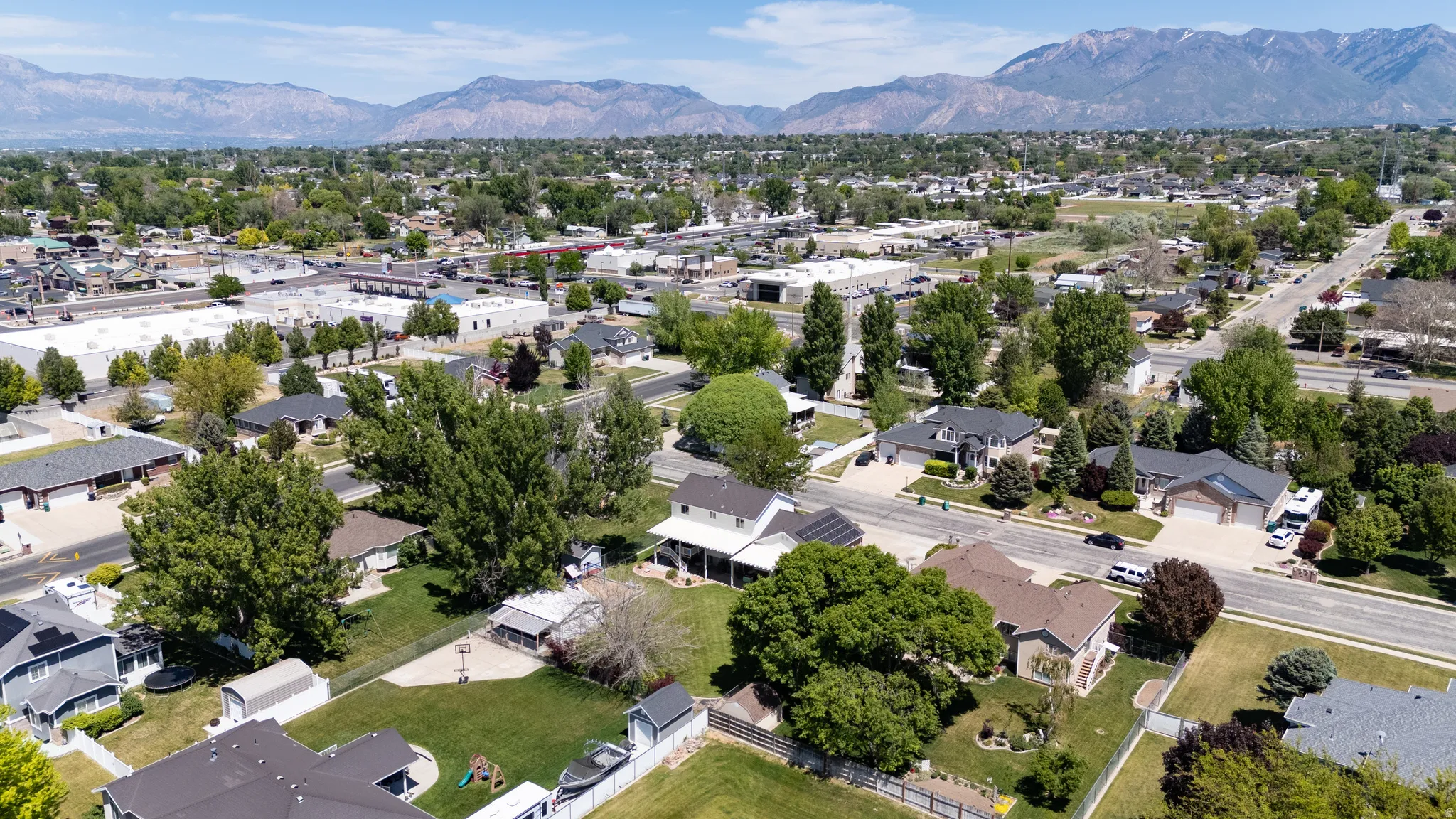 Residential neighborhood featuring mature trees and mountain backdrops