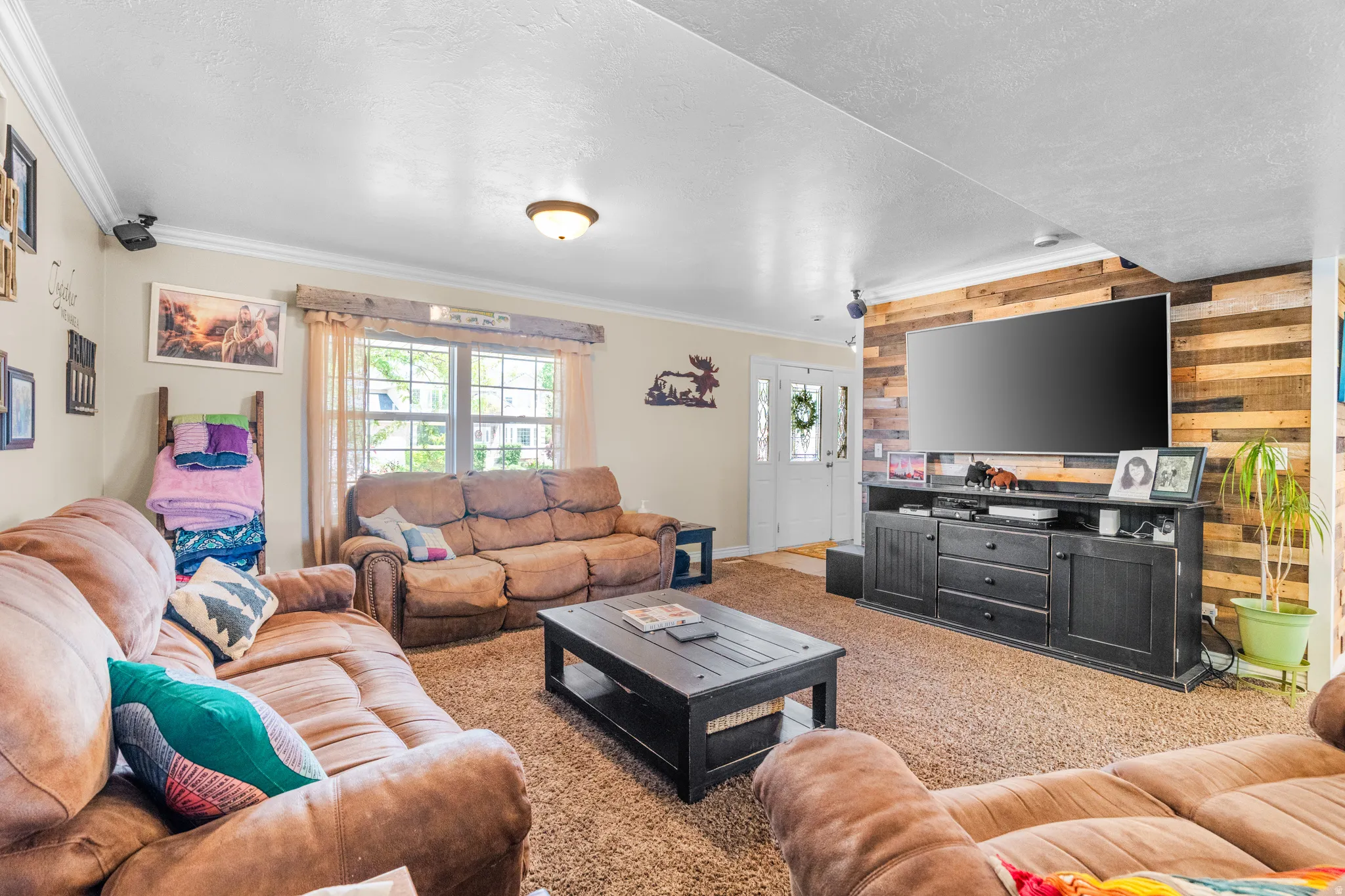 Spacious living area featuring a prominent wood plank accent wall