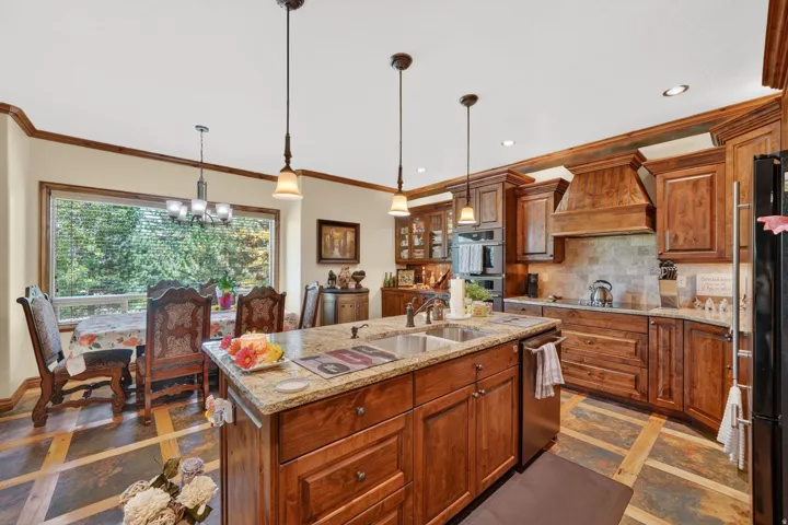 Kitchen featuring a central island with dual sinks and pendant lighting