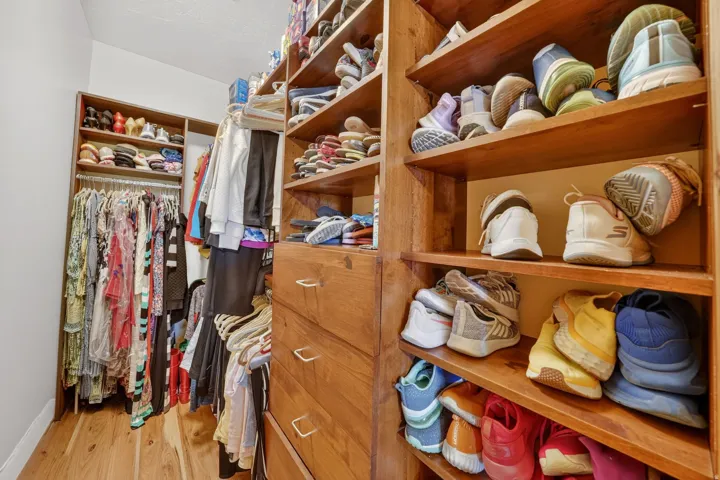 Custom closet system featuring built-in shelving, hanging rods, and integrated drawers with brass-finish hardware