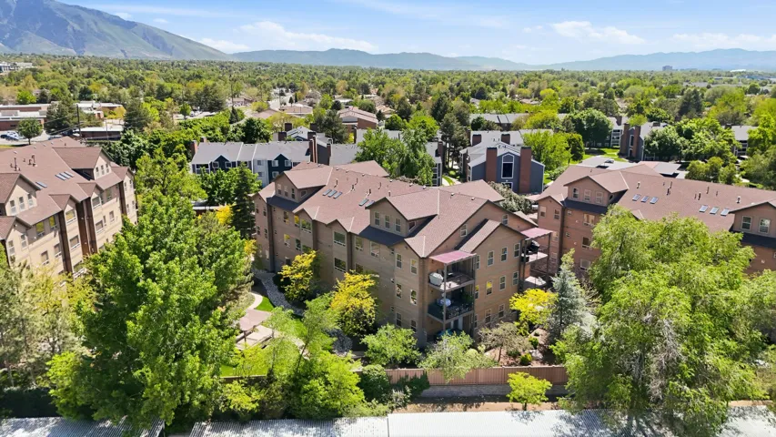 Multi-story residential complex featuring private balconies, multiple gabled roofs, and a central courtyard