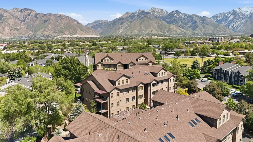 Expansive residential complex with multiple levels and balconies, set against a backdrop of distant mountains