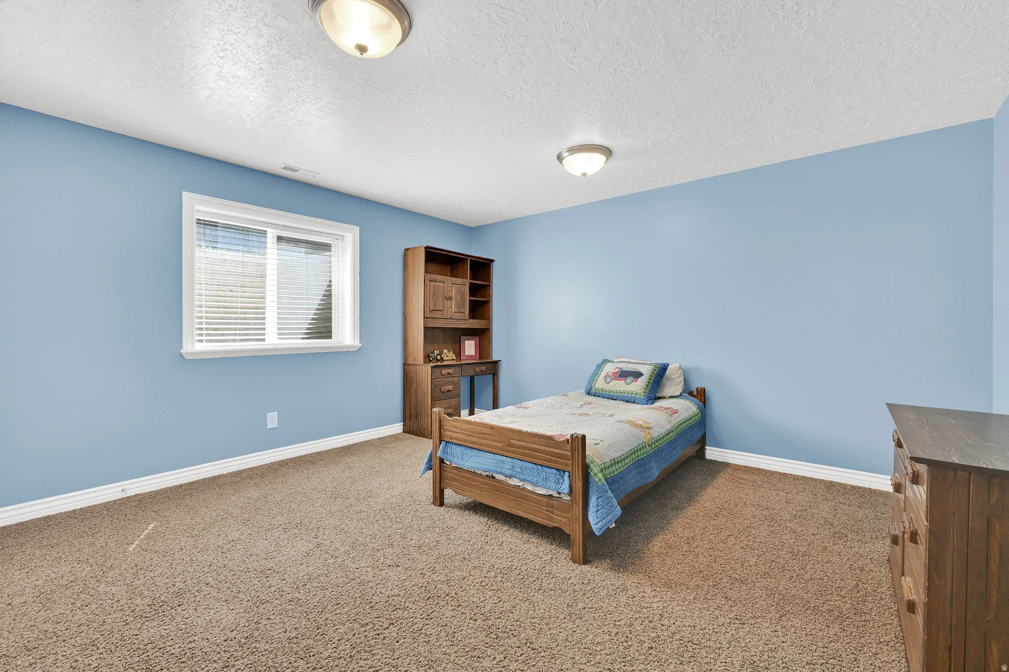 Carpeted room with a single window featuring horizontal blinds
